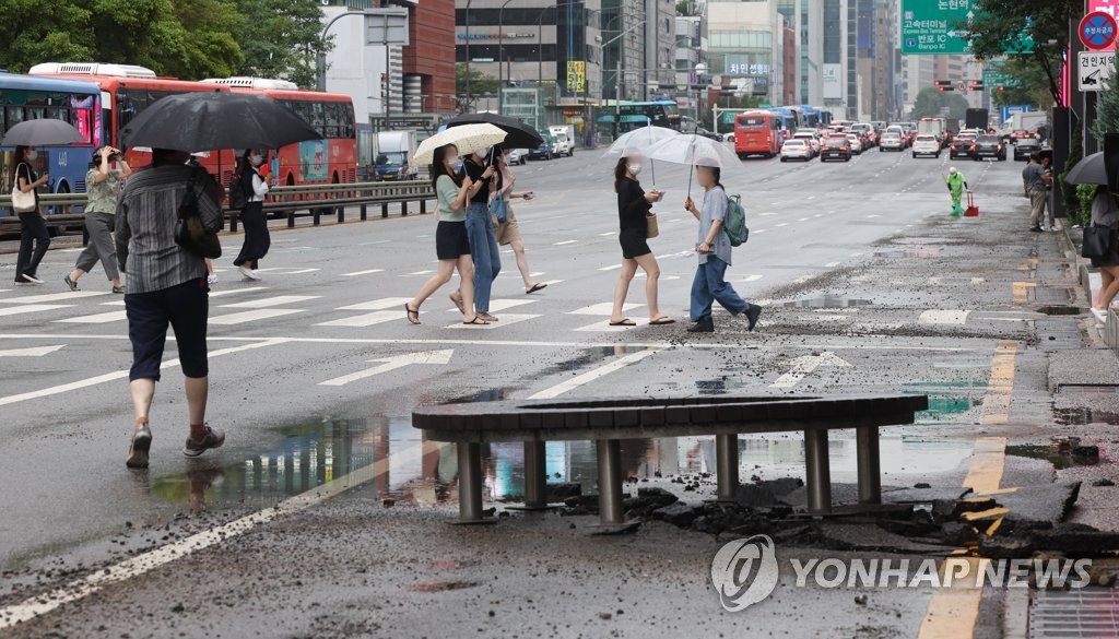 大雨の影響で破損した江南の道路＝９日、ソウル（聯合ニュース）