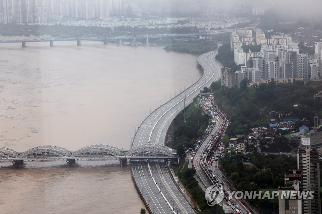 大雨により漢江の水位が上がり、通行止めとなったオリンピック大路＝９日、ソウル（聯合ニュース）