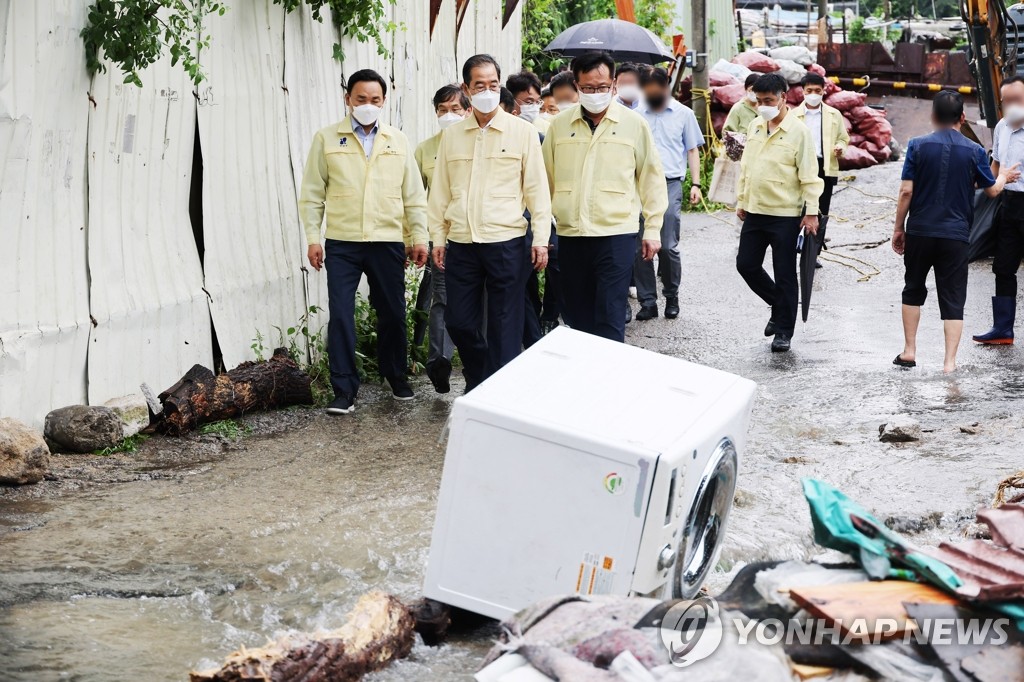 Prime Minister Han Duck-soo (C, front) inspects Guryong Village in Seoul's Gangnam Ward on Aug. 9, 2022, after about 100 residents in the village were evacuated following heavy rainfall that has pounded the capital city and parts of central South Korea since the previous day. (Yonhap)