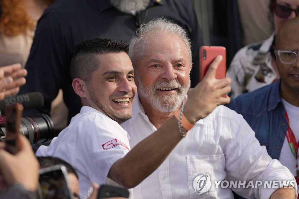 O candidato presidencial brasileiro Lula tira uma selfie com apoiadores