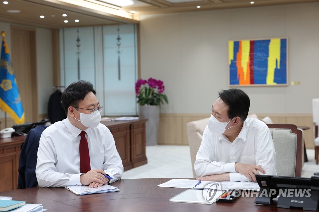 President Yoon Suk-yeol (R) is debriefed by First Vice Health Minister Cho Kyoo-hong on the ministry's agendas and initiatives at the presidential office in Yongsan, Seoul, on Aug. 19, 2022, in this photo provided by Yoon's office. (PHOTO NOT FOR SALE) (Yonhap)