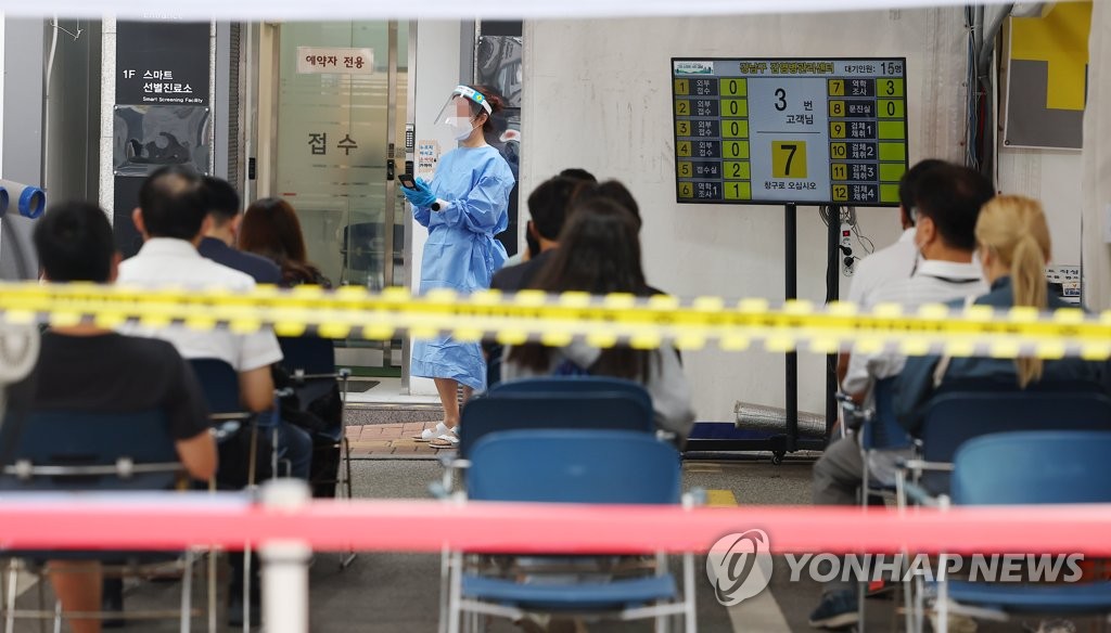 People wait to take COVID-19 tests at a clinic in Gangnam, southern Seoul, on Aug. 25, 2022. (Yonhap)