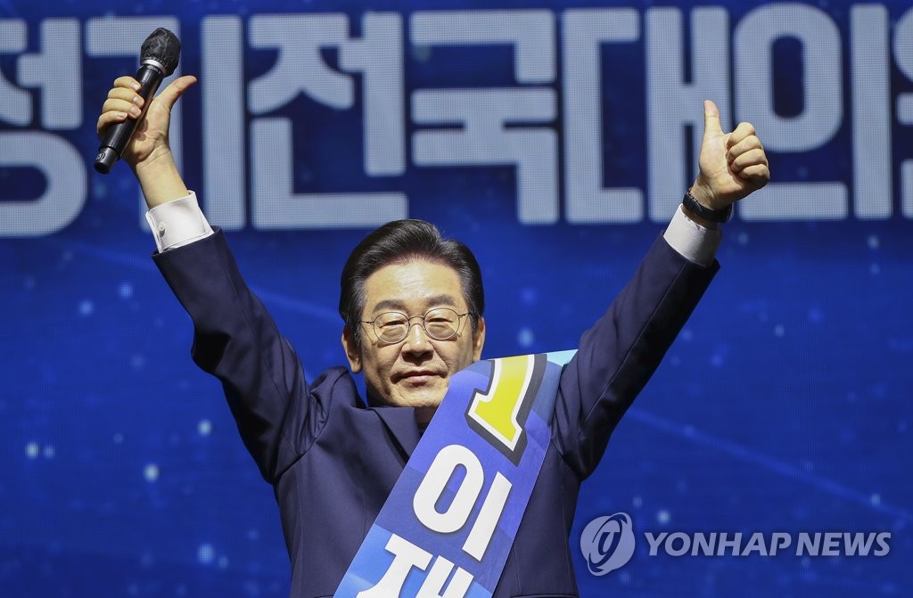 Rep. Lee Jae-myung holds his hands up during the Democratic Party's national convention, held at the gymnastics stadium in Olympic Park in western Seoul on Aug. 28, 2022, where he was elected new party chair. (Pool photo) (Yonhap)