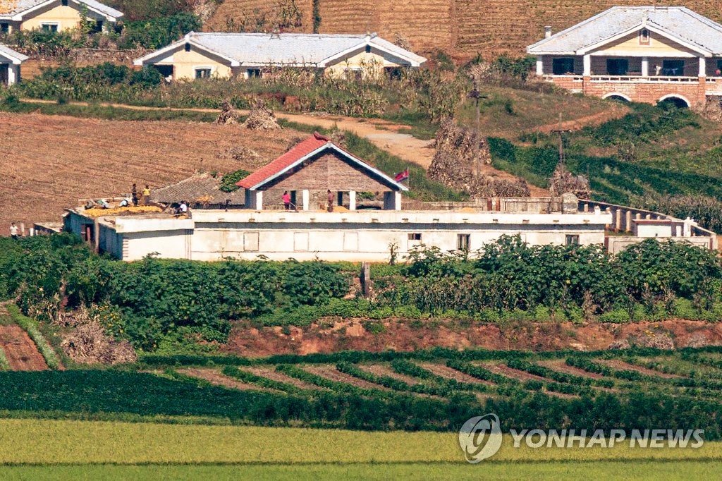 인공기 아래에서 농사일하는 북한 주민들