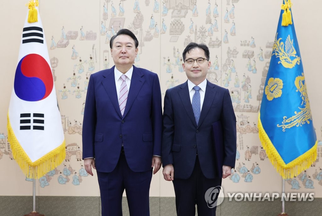 President Yoon Suk-yeol (L) poses for a photo with Han Ki-jeong, new head of the Fair Trade Commission, after presenting him with a letter of appointment at the presidential office in Seoul on Sept. 16, 2022. (Yonhap)