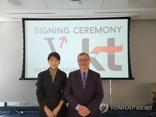 This photo provided by KT Corp. on Sept. 23, 2022, shows Kim Chae-hee (L), KT's head of strategy and planning division, and Garth Gibson, CEO of the Vector Institute, at a partnership agreement signing ceremony held in Toronto a day ago. (PHOTO NOT FOR SALE) (Yonhap)