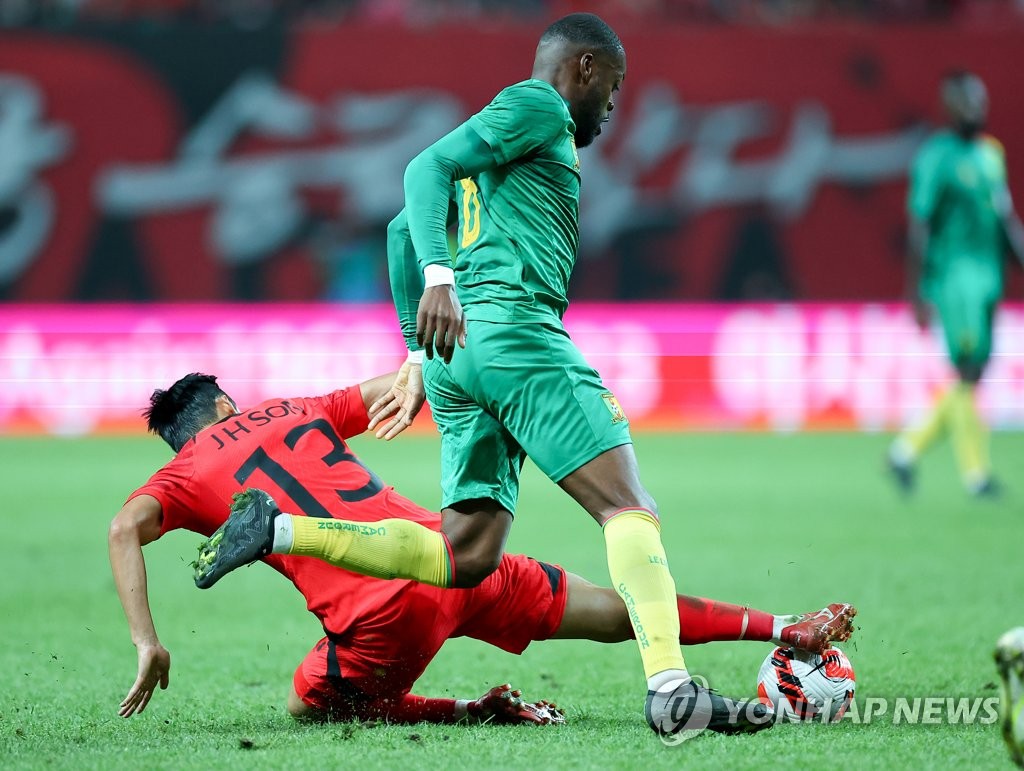 Son Jun-ho of South Korea (L) makes a tackle on Olivier Ntcham of Cameroon during the teams' men's friendly football match at Seoul World Cup Stadium in Seoul on Sept. 27, 2022. (Yonhap)