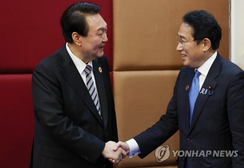 En la foto de archivo, tomada el 13 de noviembre de 2022, el presidente surcoreano, Yoon Suk Yeol (izda.), saluda con un apretón de manos al primer ministro japonés, Fumio Kishida, durante una cumbre bilateral, en un hotel de Nom Pen, Camboya.
