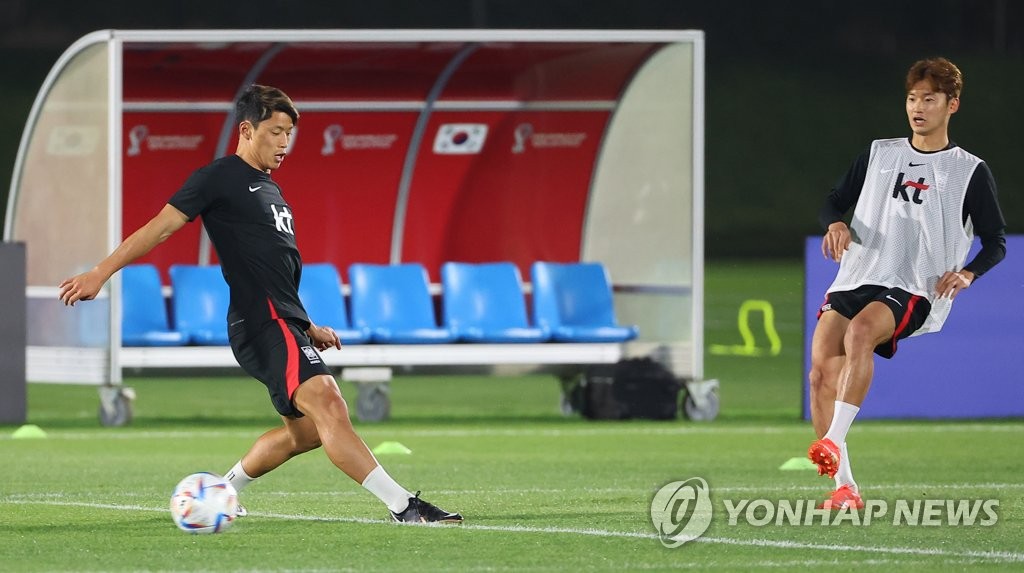 South Korean players Hwang Hee-chan (L) and Kim Jin-su train for the FIFA World Cup at Al Egla Training Site in Doha on Nov. 18, 2022. (Yonhap)