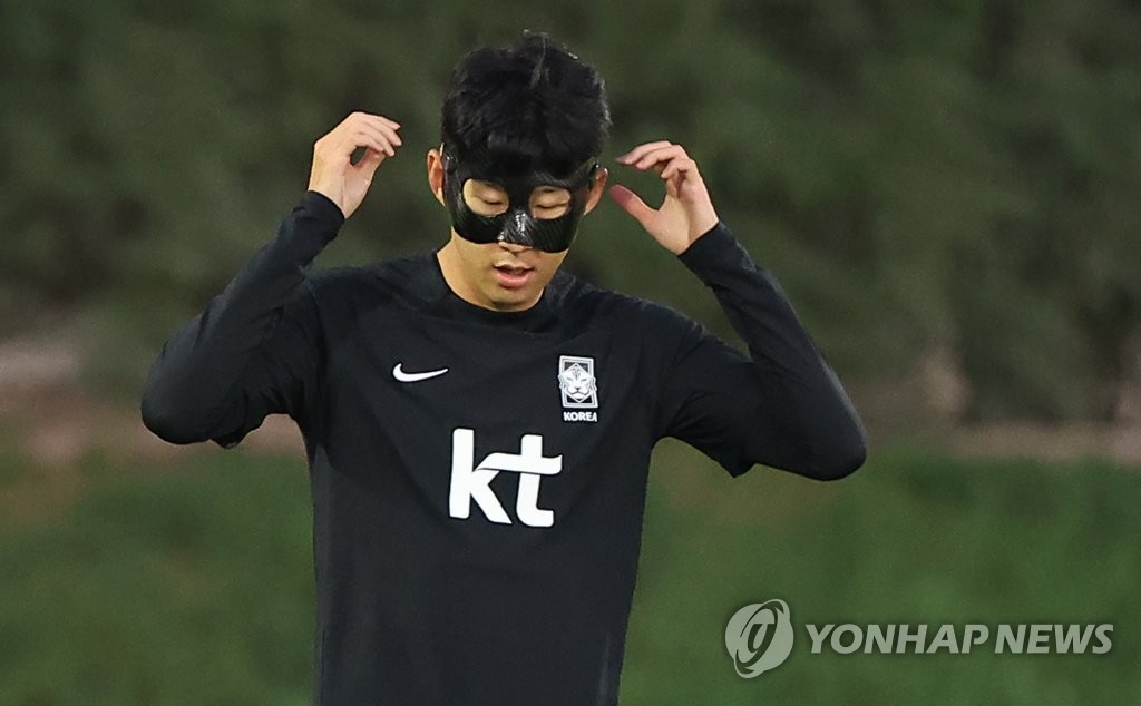 El capitán de la selección surcoreana, Son Heung-min, entrena utilizando una máscara negra sobre su rostro lastimado, el 23 de noviembre de 2022, en la Instalación de Entrenamiento Al Egla en Doha, Catar.
