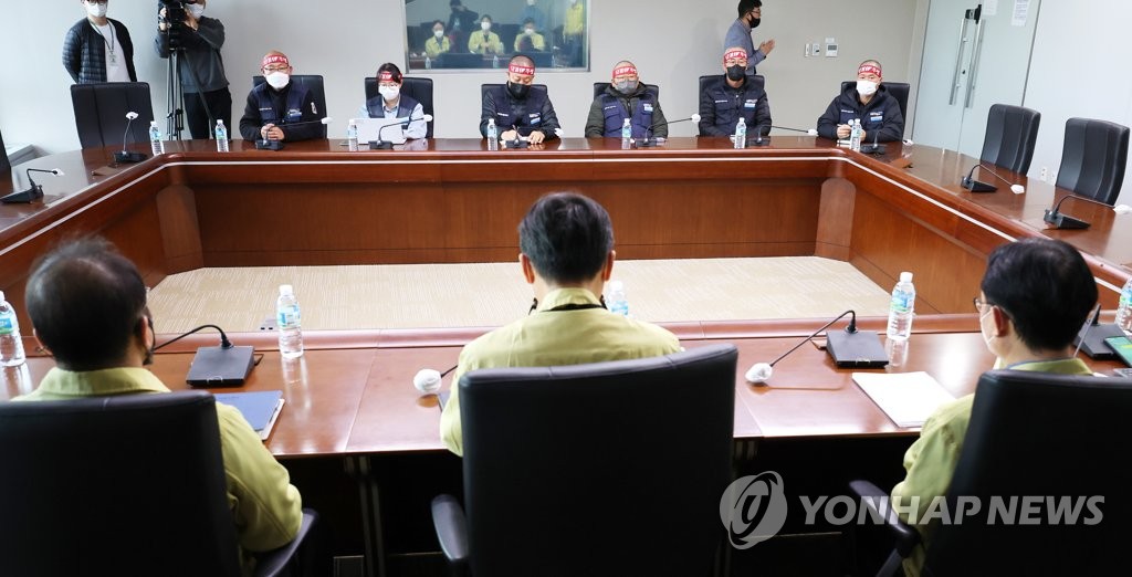Government officials and members of the Korean Public Service and Transportation Workers' Union Cargo Truckers Solidarity Division are seated to resume their negotiations on the truckers' strike at the main government complex in Sejong on Nov. 30, 2022. (Yonhap) 