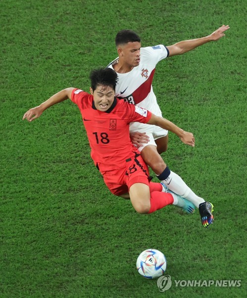 Lee Kang-in of South Korea (L) and Matheus Nunes of Portugal battle for the ball during the countries&apos; Group H match at the FIFA World Cup at Education City Stadium in Al Rayyan, west of Doha, on Dec. 2, 2022. (Yonhap)