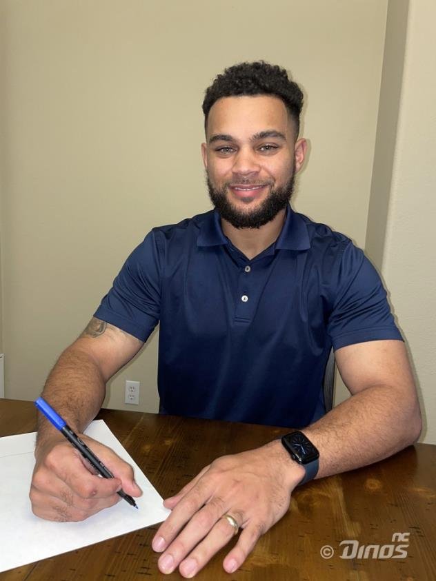 The NC Dinos' new outfielder Jason Martin signs his contract with the Korea Baseball Organization club on Dec. 9, 2022, in this photo provided by the Dinos. (PHOTO NOT FOR SALE) (Yonhap)