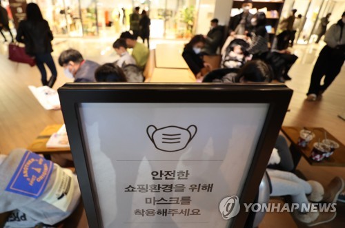 La foto de archivo, tomada el 18 de diciembre de 2020, muestra un cartel que solicita a los visitantes el uso de mascarillas, instalado en un centro comercial, en Seúl.