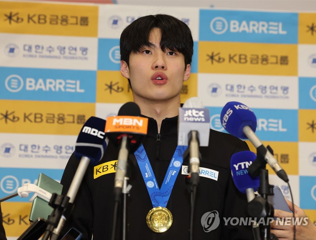 South Korean swimmer Hwang Sun-woo speaks with reporters at Incheon International Airport, west of Seoul, on Dec. 20, 2022, after arriving home with the gold medal from the men's 200-meter freestyle at the FINA Short Course World Swimming Championships. (Yonhap)