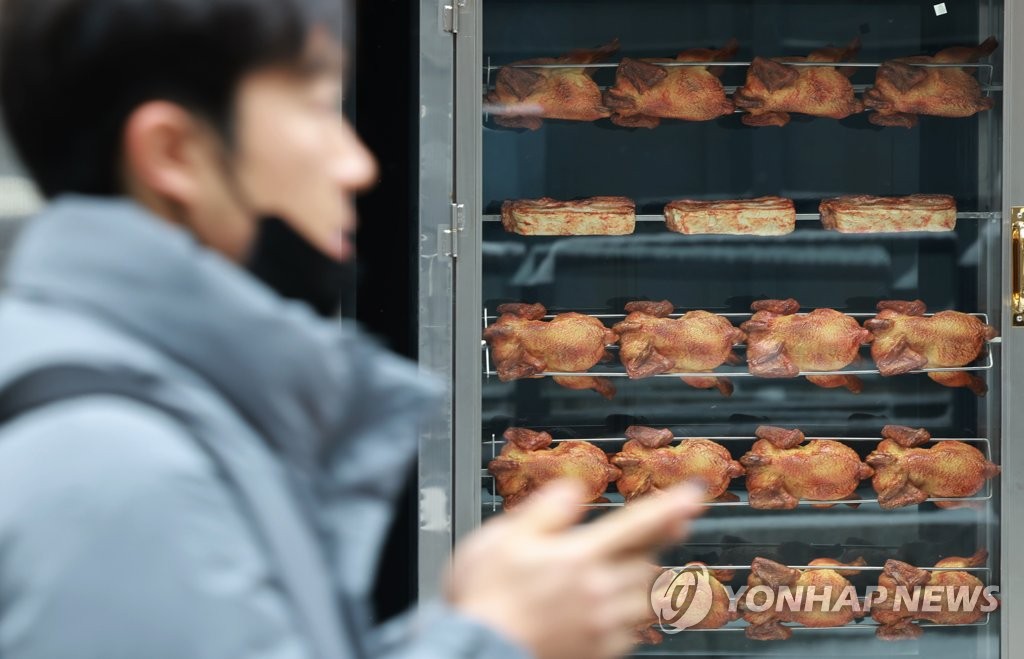 A man walks by a food stall in central Seoul, in this file photo taken Jan. 26, 2023. (Yonhap)