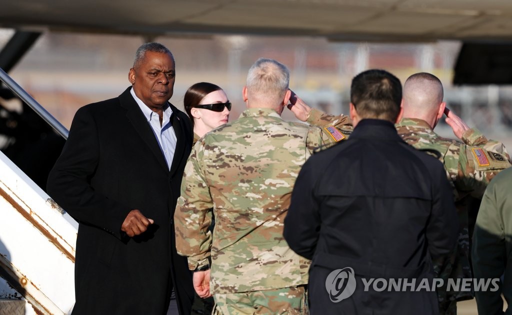 Le secrétaire américain à la Défense Lloyd Austin est salué le lundi 30 janvier 2023 par le commandant des Forces américaines en Corée du Sud, le général Paul LaCamera, à son arrivée à la base aérienne d'Osan, au sud de Séoul. (Pool photo)