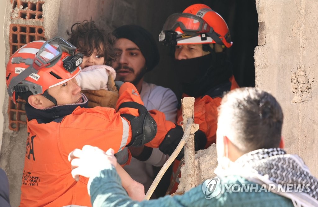 This photo provided by the Korea Disaster Relief Team shows South Korean workers rescuing a toddler in Antakya, in the Turkish province of Hatay, on Feb. 9, 2023, after a deadly 7.8 magnitude earthquake hit Turkey and Syria on Feb. 6. (Yonhap)