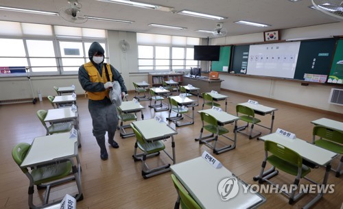 Un agent sanitaire désinfecte le 27 février 2023 une salle de classe dans une école élémentaire à Cheongju, dans la province du Chungcheong du Nord. 