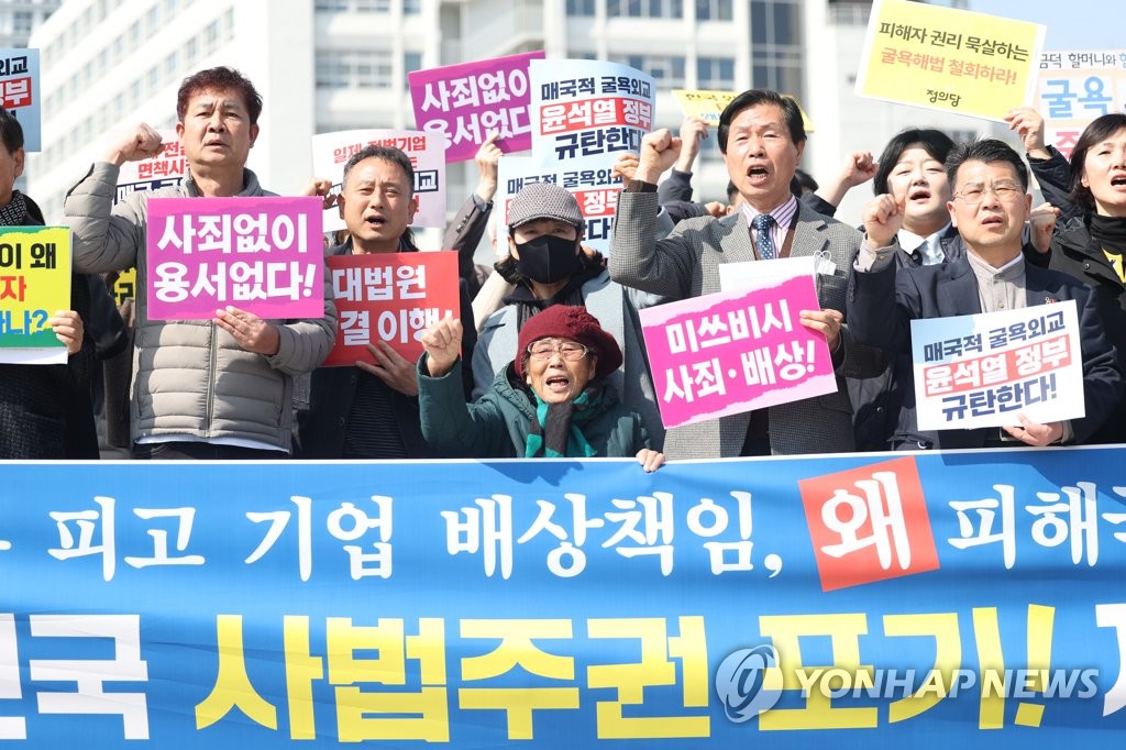 Yang Geum-deok (C), a forced labor victim, and activists condemn a government plan to compensate victims of Japan's wartime forced labor without involvement of responsible Japanese firms in an event on March 6, 2023, in the southern city of Gwangju. (Yonhap)