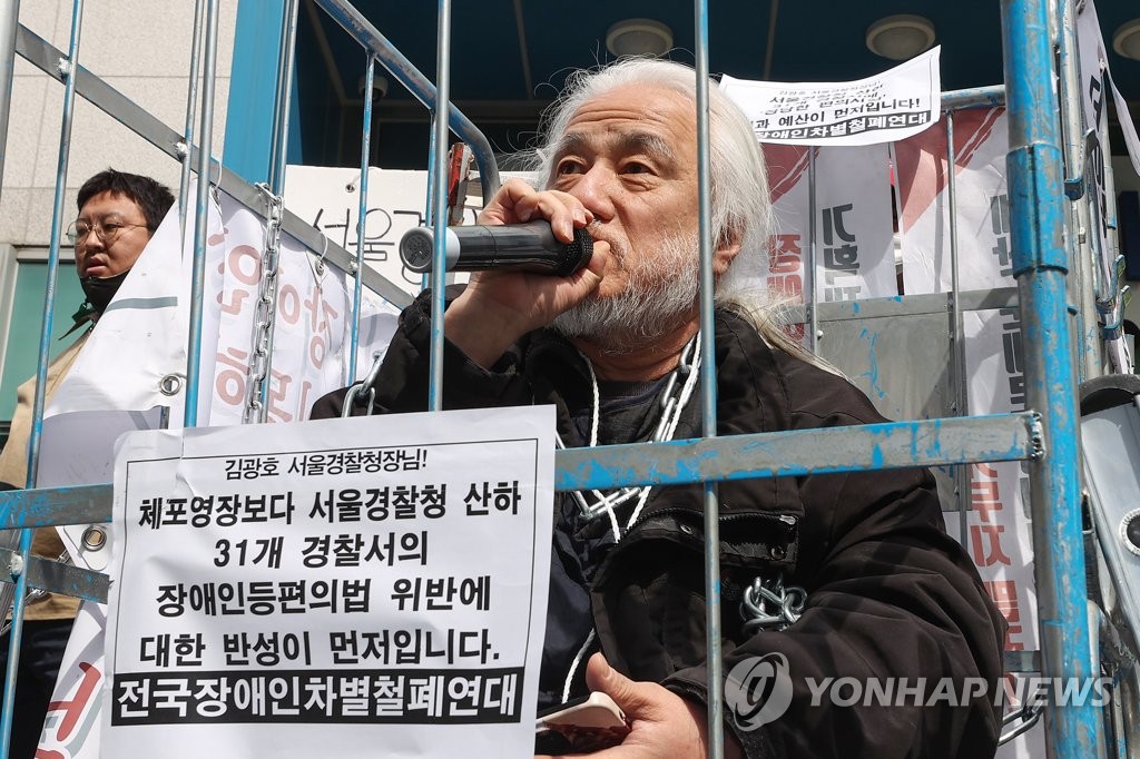 Park Kyoung-seok, the 63-year-old leader of the Solidarity Against Disability Discrimination (SADD), speaks inside a cage during a press conference in Seoul on March 17, 2023, before police arrested him on illegal demonstration charges. (Yonhap)