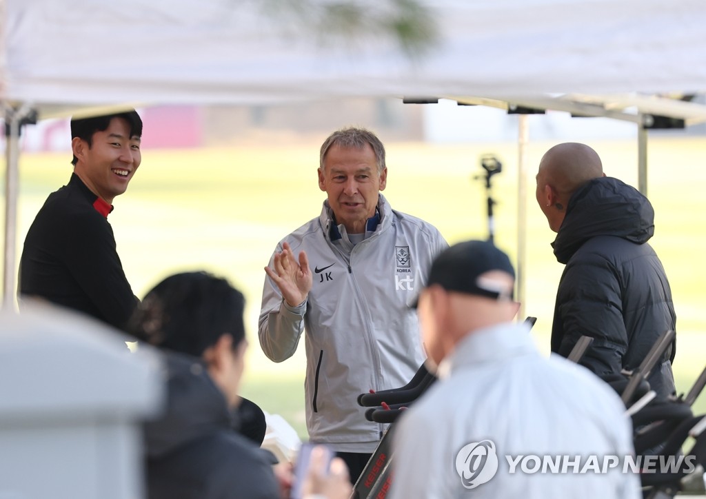 한국의 미드필더 손흥민(왼쪽)이 2023년 3월 21일 서울에서 북서쪽으로 30km 떨어진 파주 국가대표축구센터에서 열린 훈련 세션에 앞서 위르겐 클린스만 감독(가운데)의 설명을 듣고 있다.