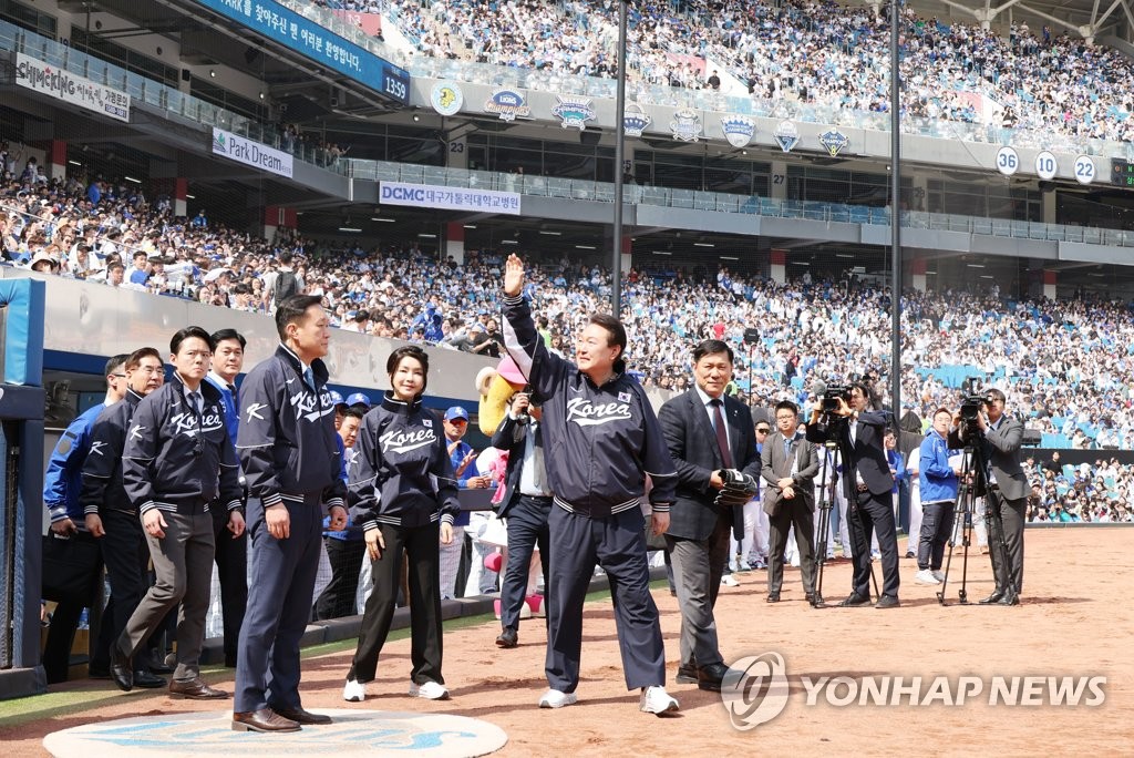 President Yoon Suk Yeol (2nd from R) waves to fans at Daegu Samsung Lions Park in Daegu, some 240 kilometers southeast of Seoul, before throwing the ceremonial first pitch before a Korea Baseball Organization Opening Day game between the Lions and the NC Dinos on April 1, 2023. (Yonhap)