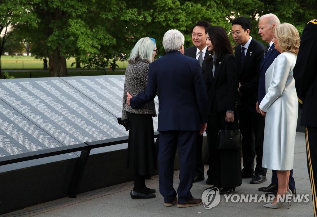 South Korean President Yoon Suk Yeol (3rd from L), U.S. President Joe Biden (2nd from R), South Korean first lady Kim Keon Hee (4th from L) and U.S. first lady Jill Biden (R) meet with a family member of a service member killed in the Korean War in front of the Wall of Remembrance at the Korean War Veterans Memorial in Washington on April 25, 2023. (Yonhap)