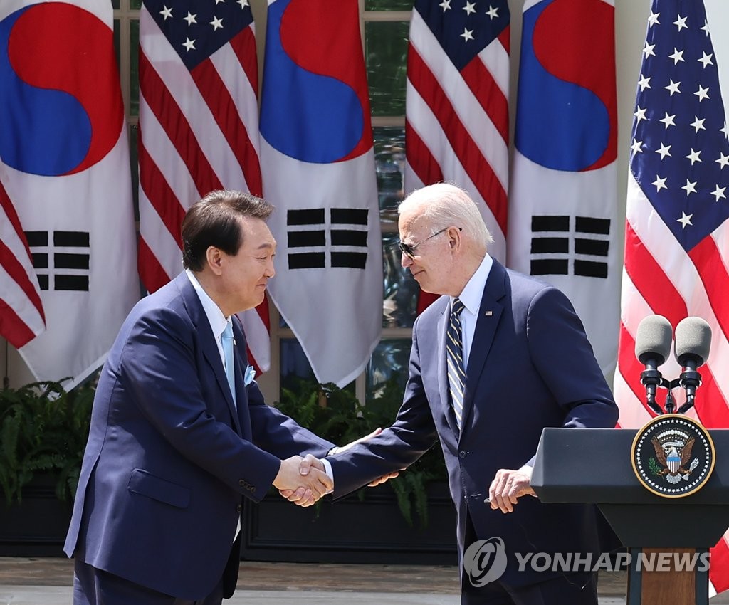 South Korean President Yoon Suk Yeol (L) shakes hands with U.S. President Joe Biden during a joint news conference after their summit at the White House in Washington, D.C., on April 26, 2023. (Yonhap)