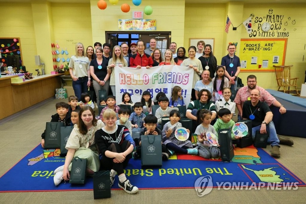 Prime Minister Han Duck-soo (C, standing), family members of U.S. Forces Korea personnel and students pose for a photo at Humphreys West Elementary School in Camp Humphreys in Pyeongtaek, 70 kilometers south of Seoul, on April 28, 2023, in this photo released by his office. (PHOTO NOT FOR SALE) (Yonhap)