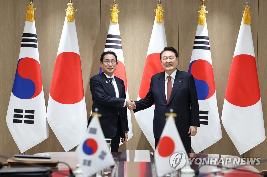 President Yoon Suk Yeol (R) shakes hands with Japanese Prime Minister Fumio Kishida prior to their bilateral summit at the presidential office in Seoul on May 7, 2023. (Yonhap)