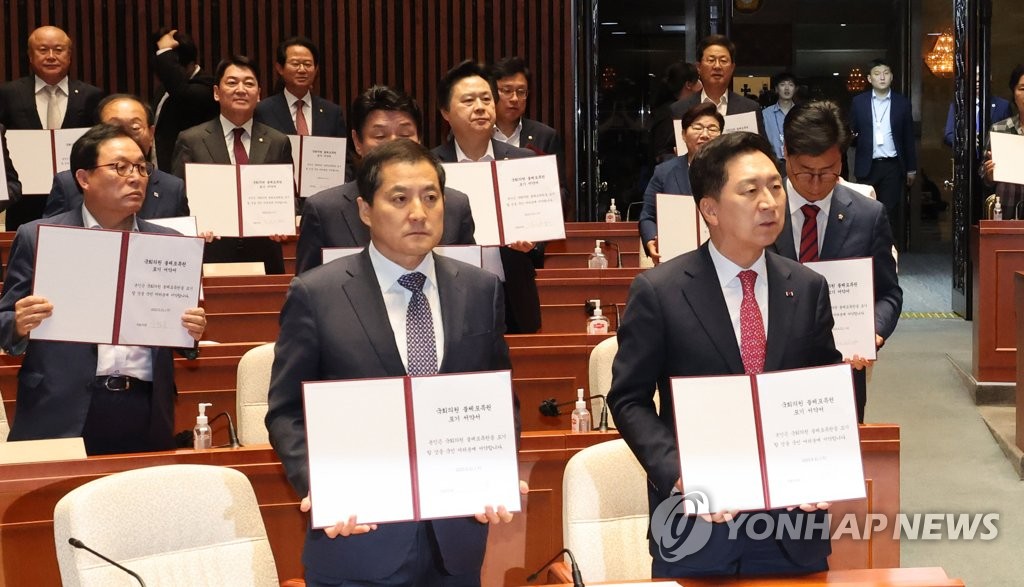 Ruling People Power Party lawmakers pose for a photo at the National Assembly in Seoul on June 21, 2023, while holding their oath to give up their immunity from arrest.