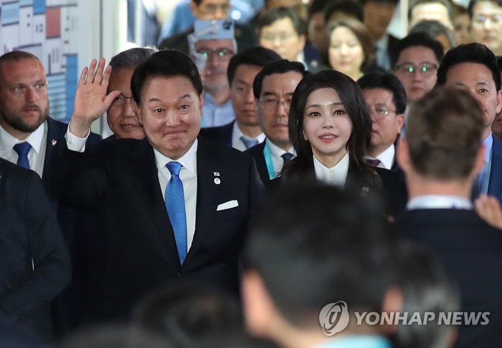 El presidente de Corea del Sur, Yoon Suk Yeol (izquierda), saluda al ingresar a la recepción oficial de la Exposición Universal de Busan 2030 en un centro deportivo en Issy-les-Moulineaux, en las afueras de París, junto con la primera dama Kim Keon Hee, el 21 de junio de 2023. (Yonhap)