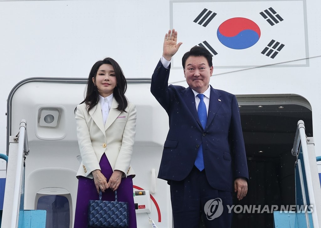 President Yoon Suk Yeol (R) and first lady Kim Keon Hee bid farewell while boarding the presidential plane at Noi Bai International Airport in Hanoi, in this file photo taken June 24, 2023, after a three-day state visit to Vietnam. (Yonhap)