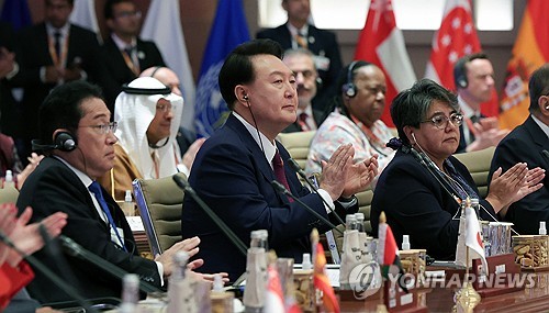 President Yoon Suk Yeol (C) claps at a Group of 20 summit meeting held at Bharat Mandapam International Exhibition-Convention Centre in New Delhi on Sept. 9, 2023. On the left is Japanese Prime Minister Fumio Kishida. (Pool photo) (Yonhap)