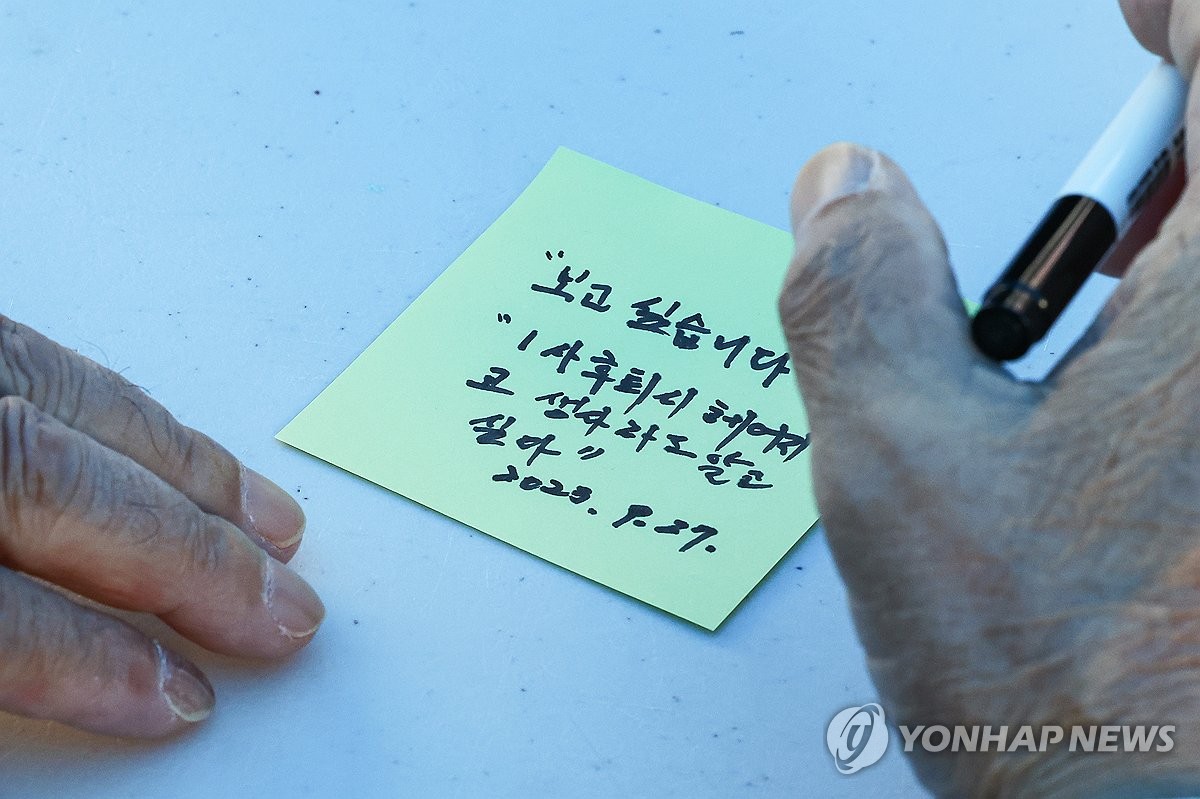 Esta fotografía de archivo del 27 de septiembre de 2023 muestra a un miembro de una familia separada por la Guerra de Corea de 1950-53 escribiendo un mensaje durante un evento celebrado en Seúl para conmemorar el día en que se conmemora a las familias separadas.  (Yonhap)