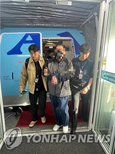 A man in custody arrives at Incheon International Airport, west of Seoul, on April 17, 2024, in this photo provided by the National Police Agency. The fugitive, suspected of committing massive fraud, was detained 12 years after fleeing to Kuwait. (PHOTO NOT FOR SALE) (Yonhap)