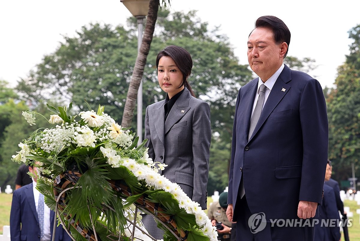 El presidente Yoon Suk Yeol (derecha) y la primera dama Kim Keon Hee depositan coronas de flores en el pilón conmemorativo de la Guerra de Corea en el Cementerio de los Héroes de Manila para honrar a los veteranos filipinos que lucharon en la Guerra de Corea de 1950-53 el 6 de octubre de 2024. (Yonhap )