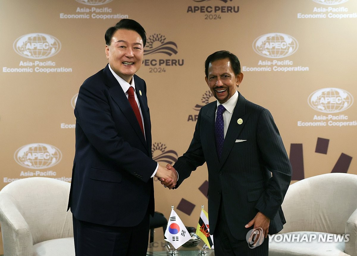 El presidente Yoon Suk Yeol (izq.) le da la mano al sultán Hassanal Bolkiah de Brunei durante una cumbre celebrada en el Centro de Convenciones de Lima, Perú, el 15 de noviembre de 2024. (Foto de la piscina) (Yonhap)