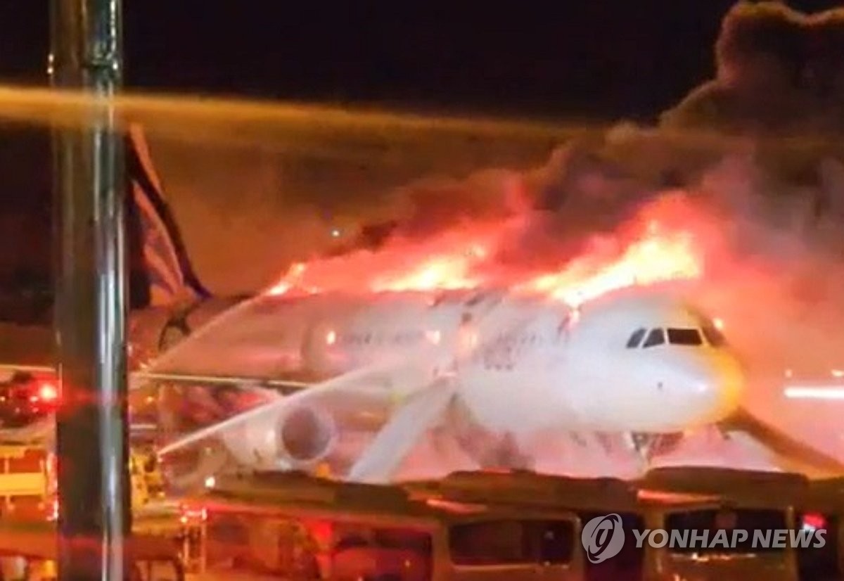 Esta foto proporcionada por un lector muestra un avión Air Busan en llamas en el Aeropuerto Internacional de Gimhae en Busan, a 320 kilómetros al sureste de Seúl, el 28 de enero de 2025. Las autoridades de bomberos dijeron que los 169 pasajeros y siete miembros de la tripulación evacuaron de manera segura. (Foto no a la venta) (Yonhap)