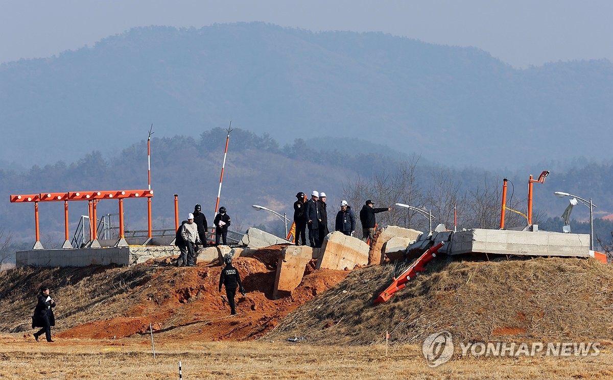 This Feb. 26, 2025, file photo shows officials inspecting a localizer facility involved in a fatal aircraft crash of South Korean low-cost carrier Jeju Air. (Yonhap)
